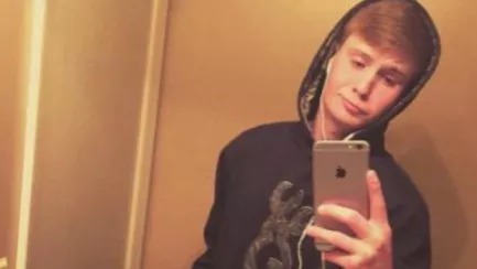 Timothy Wilks, de 20 anos, morreu ao ser baleado durante a gravação de uma pegadinha Jovem de moletom cinza e fones de ouvido brancos tira selfie com smartphone prateado.