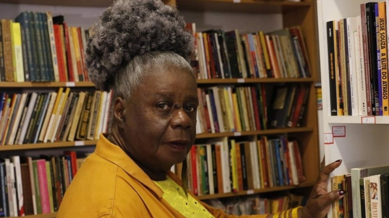 A escritora Conceição Evaristo, homenageada por Angela Davis, durante a 24ª Flip em Paraty. Conceição Evaristo em livraria, cabelo crespo, blusa amarela, tocando livro na prateleira