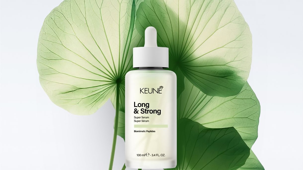 Frasco branco Keune Long & Strong Super Serum com conta-gotas em fundo de folhas verdes