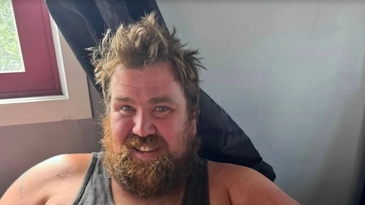 O influenciador de culinária Joel Yukich, conhecido por seu perfil “Blokes Can Cook Too”, faleceu aos 35 anos após um “evento médico” súbito. Homem sorrindo com barba cheia e cabelo espetado, usando regata cinza, olhando para a câmera.