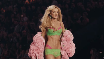 Carol Trentini desfila com lingerie verde e rosa e casaco floral rosa na passarela