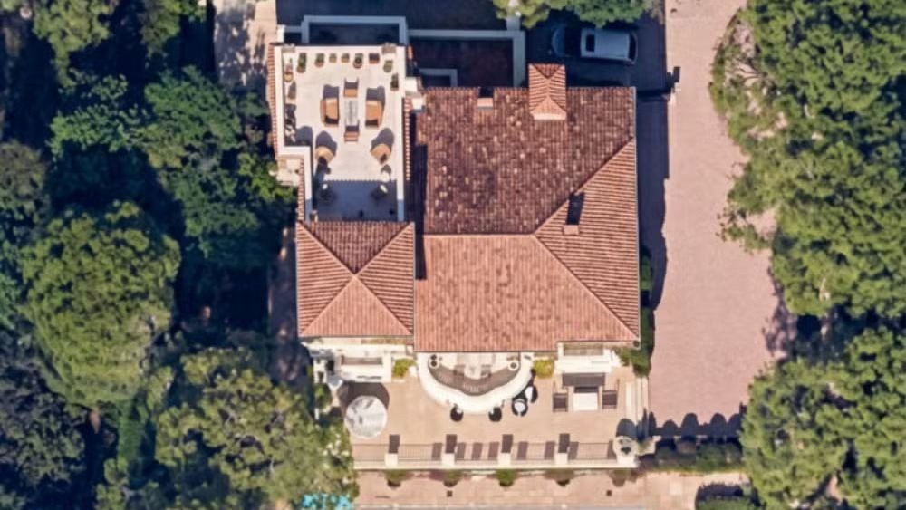 A casa de Dave Grohl em Encino, Califórnia, uma das luxuosas residências dos artistas do Rock in Rio 2026 Vista aérea de casa com telhado de telha, pátio com móveis, árvores e carro na entrada