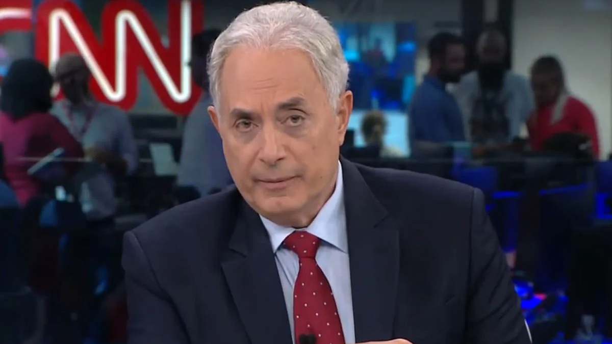 William Waack, o jornalista que se reergueu na CNN Brasil após a polêmica que custou seu cargo na TV Globo. Homem de cabelos grisalhos, terno azul e gravata vermelha pontilhada, em estúdio com logo CNN.