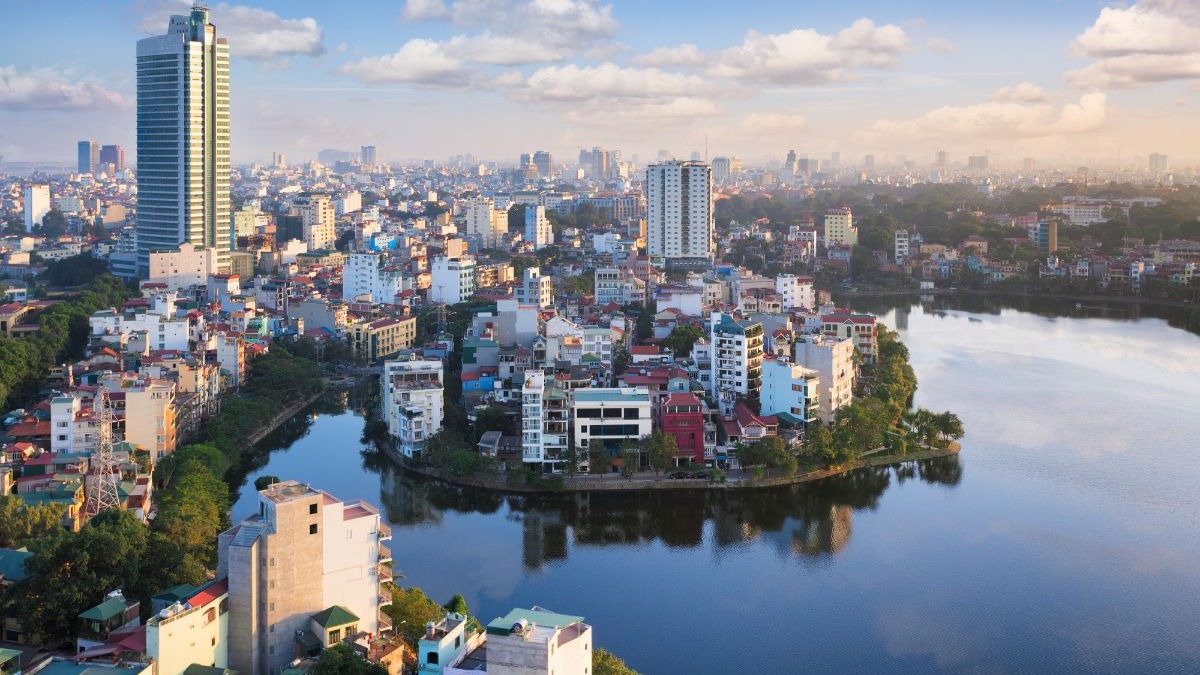 Vista a&eacute;rea de cidade urbana com lago azul, arranha-c&eacute;u alto e muitos edif&iacute;cios.