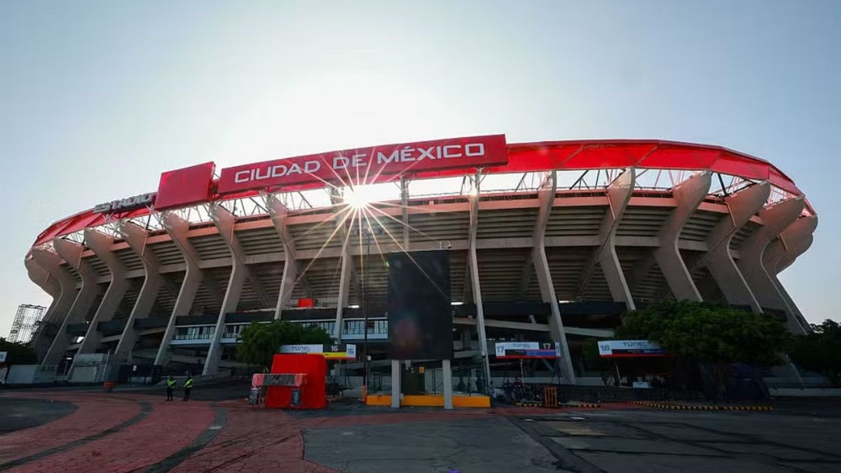 O icônico Estádio Azteca, na Cidade do México, palco da abertura da Copa do Mundo de 2026 e de momentos históricos do futebol. Estádio Azteca, Cidade do México, fachada externa com letreiro vermelho "CIUDAD DE MÉXICO", sol.