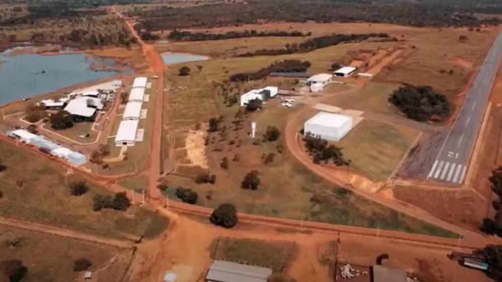 Vista aérea de fazenda com lago, edifícios e pista de pouso particular marcada com 21
