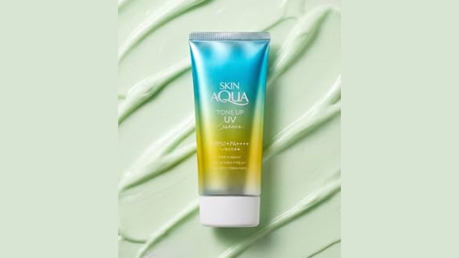 Tubo Skin Aqua Tone Up UV Essence azul-amarelo, sobre fundo cremoso verde com padr&otilde;es