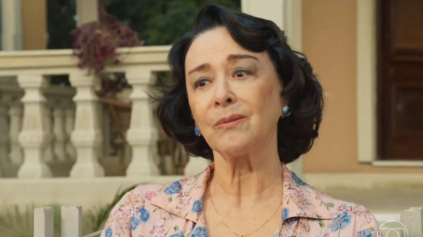 Nívea Maria é confirmada no elenco da sequência de "Avenida Brasil" pela emissora. Foto: Reprodução Retrato de Nívea Maria, idosa, blusa floral, brincos azuis