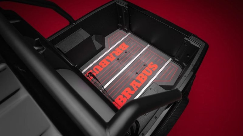 Ca&ccedil;amba preta de ve&iacute;culo com piso escuro exibindo logotipo BRABUS em vermelho e listras brancas