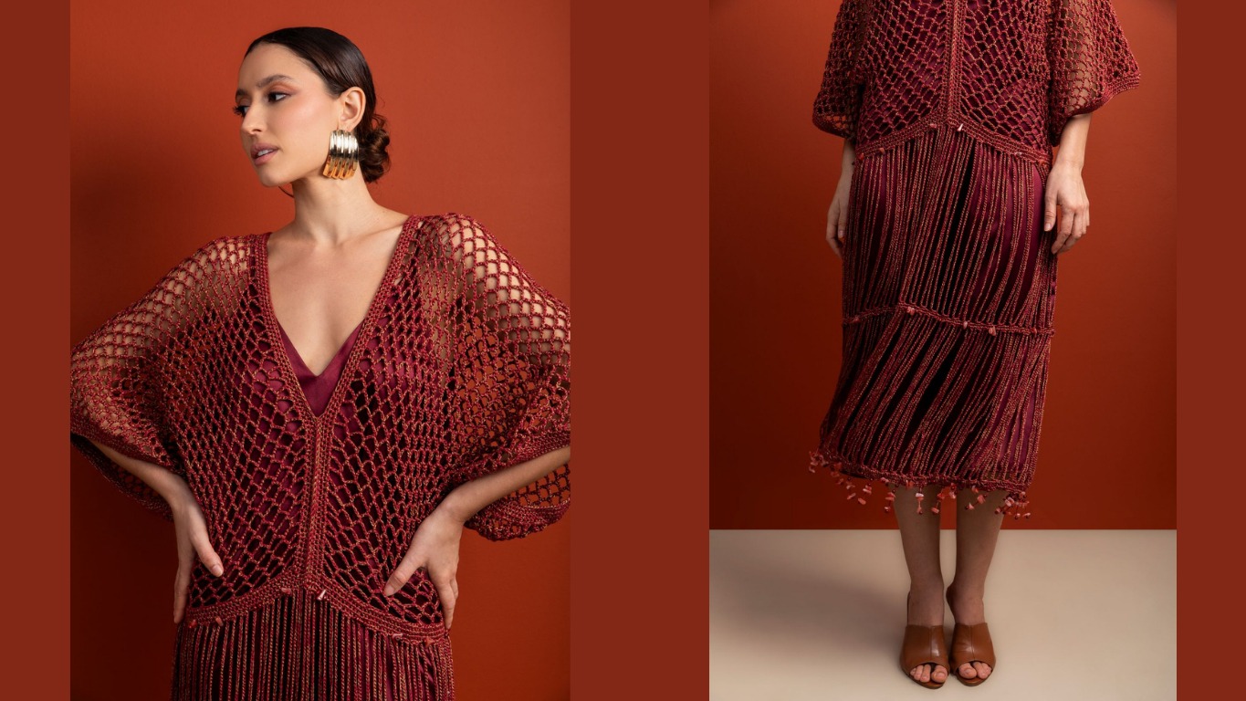 Modelo posa com vestido longo de croch&ecirc; bord&ocirc; com franjas, em fundo laranja