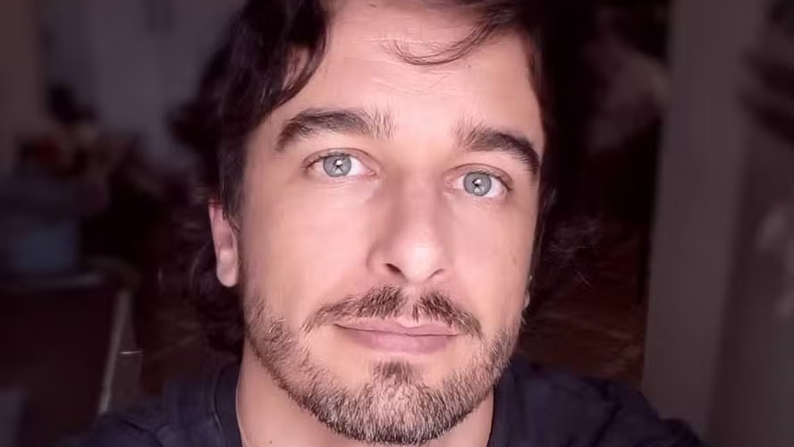 O ator Marco Furlan, acusado de estupro de vulnerável, permanece à disposição da Justiça de São Paulo Close-up do rosto de um homem com cabelo escuro, barba e olhos claros