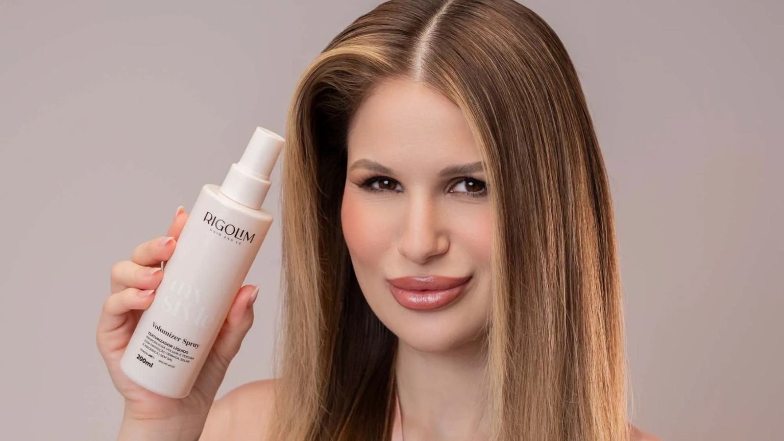 Mulher com cabelo castanho e volumoso segura spray Rigolim My Style Volumizer 200ml