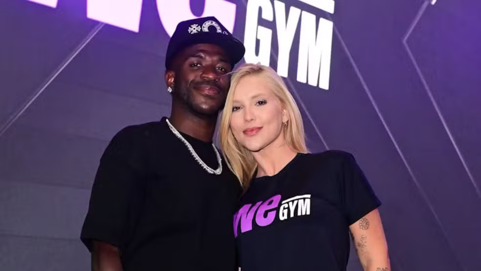Virginia Fonseca e Vini Jr. posam juntos em evento que marcou a oficialização da volta do namoro e a inauguração da academia da influenciadora — Foto: Reprodução/Redes Sociais Virginia Fonseca e Vini Jr. sorrindo, ele de boné, ela com camiseta we GYM em evento