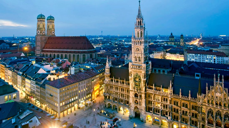 Munique, a capital da Baviera, oferece infraestrutura e qualidade de vida que atraem os principais talentos do futebol europeu. Vista aérea noturna de Munique com a Frauenkirche e a Nova Prefeitura iluminadas.