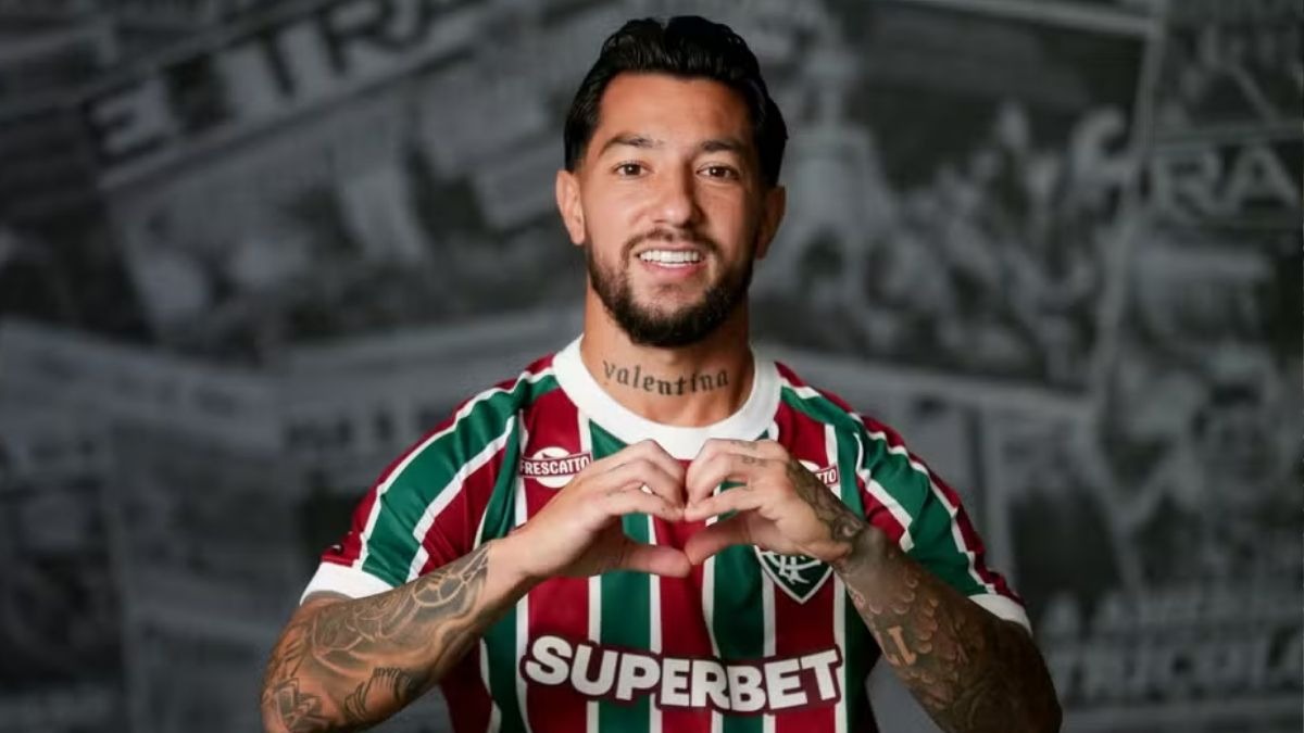 Lucho Acosta, meio-campista do Fluminense, personagem central na investigação sobre um cartão amarelo suspeito no Brasileirão. Meio-campista Lucho Acosta, Fluminense, sorrindo, fazendo coração com as mãos, camisa listrada, tatuagem "Valentina"