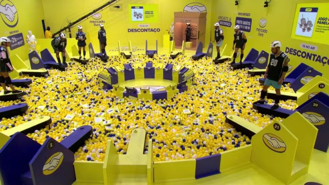 A Prova do Líder do BBB26 desafia participantes em uma disputa de resistência que exige foco e preparo físico. Competidores em prova de resistência sobre plataformas suspensas em uma piscina de bolinhas coloridas.