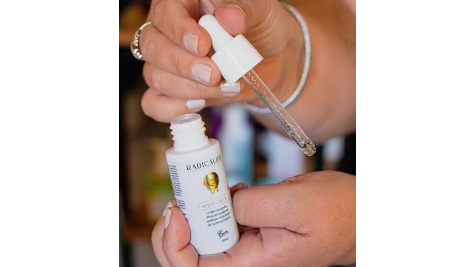 M&atilde;os seguram um frasco branco de s&eacute;rum Radicaline Pierre com conta-gotas em destaque.