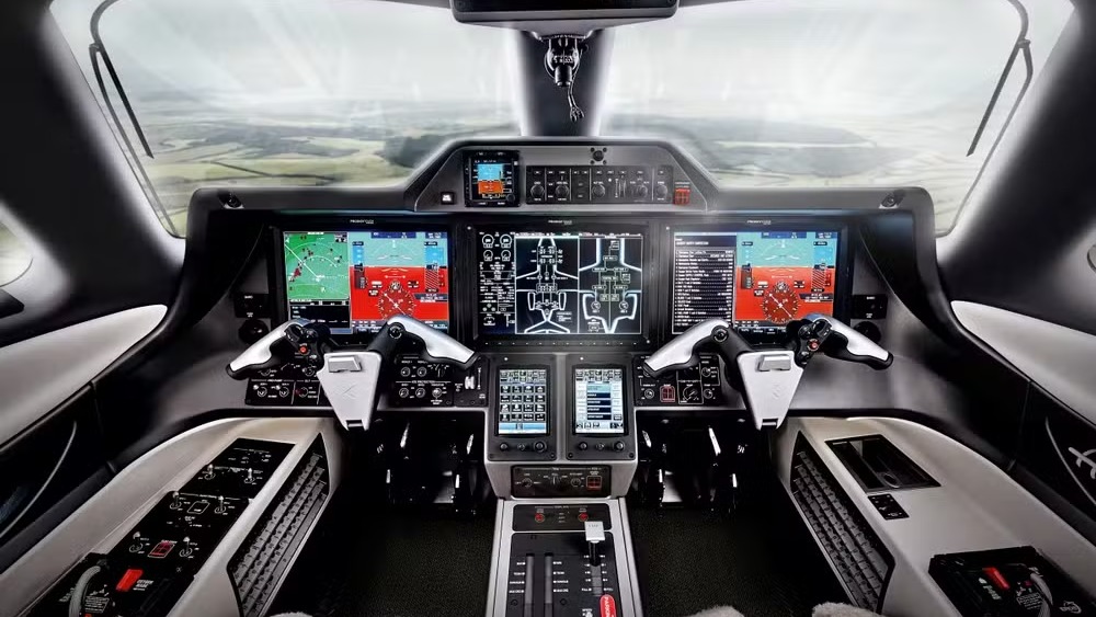 O sofisticado cockpit do Phenom 300EV, equipado com o avançado sistema Garmin Emergency Autoland para pouso automático Cockpit moderno de aeronave com múltiplas telas digitais e controles de voo