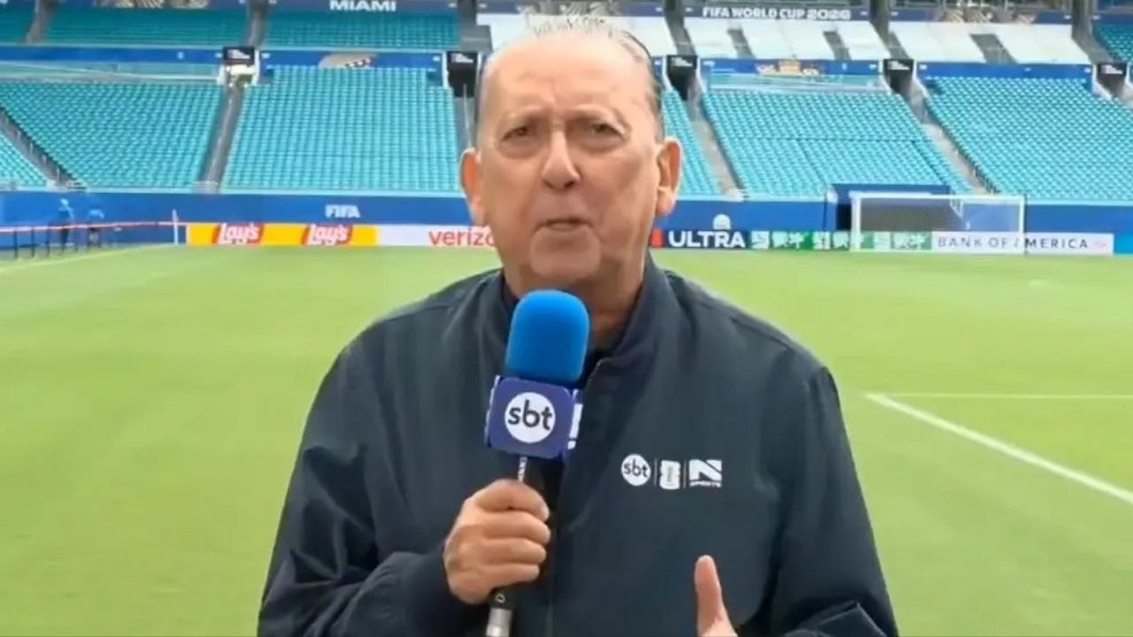 Galvão Bueno na transmissão da Copa do Mundo de 2026 pelo SBT, em novo capítulo de sua carreira na emissora. Foto: Reprodução Homem de meia-idade, calvo, jaqueta escura, segura microfone do SBT em estádio.