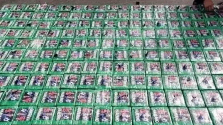 Os pacotes de cocaína apreendidos no Equador exibiam adesivos com o rosto do jogador Haaland, prática usada para identificar a carga ilícita. Foto: Reprodução Dezenas de pacotes de cocaína embrulhados em verde com adesivos de Haaland sobre uma superfície