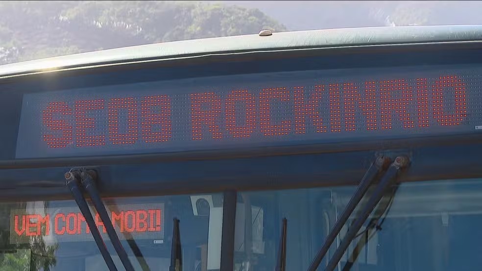 Placa de BRT exibe a linha SE008, uma das opções do Expresso Rock in Rio para levar fãs ao festival. Display eletrônico de BRT mostra 'SE008 TERMINAL JARDIM OCEÂNICO' e 'VEM COM A MOBI!'