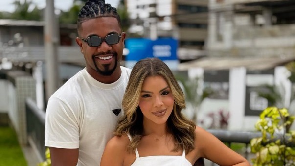 Davi Brito e Emilly Araújo, o casal cujo casamento civil surpreendeu a mãe do ex-BBB. Homem de tranças, óculos escuros e barba, com mulher de cabelo comprido sorrindo