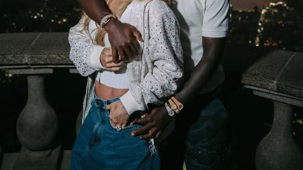 Vini Jr. e Virginia Fonseca em foto que viralizou, destacando os três relógios do jogador que inspiraram a "teoria dos fusos" Homem e mulher abraçados. Ele exibe três relógios no pulso, ela jaqueta brilhante