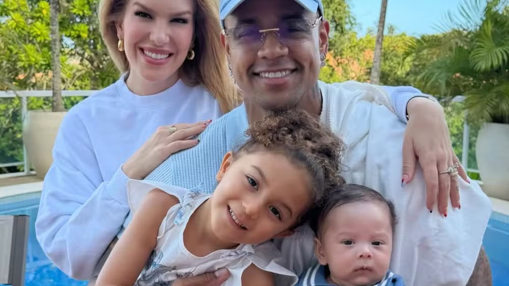 Lorena Improta e Léo Santana posam com os filhos Liz e Levi, que a dançarina brinca se parecerem com o pai. Lorena Improta e Léo Santana sorrindo com a filha Liz e o bebê Levi ao ar livre