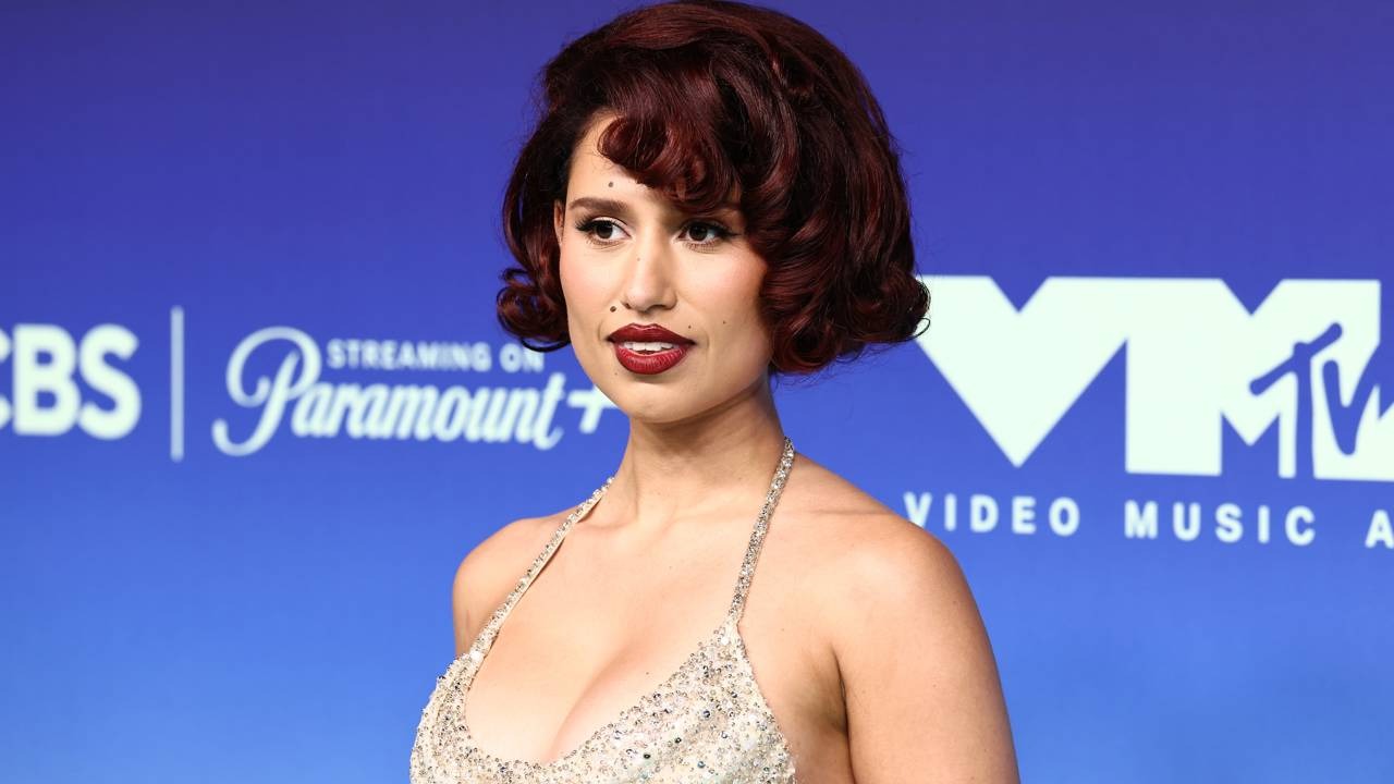Raye, uma das atrações confirmadas do Lollapalooza Brasil 2027, posa em evento da MTV. Cantora Charli XCX com cabelo ruivo, batom vermelho, posa em evento com logos da MTV e Paramount+
