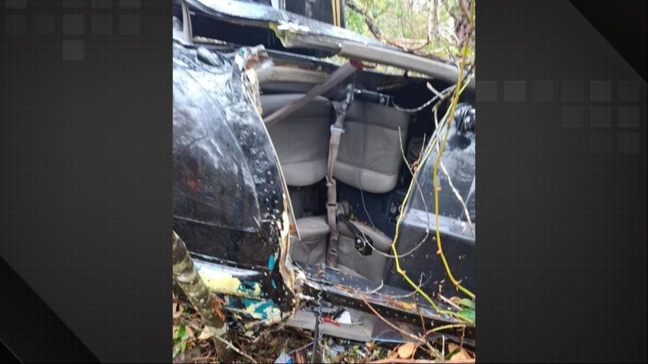 Confira as imagens dos destroços do helicóptero que caiu com o cantor Rick e outras quatro pessoas em Santa Catarina. Foto: Reprodução Interior de helicóptero preto acidentado em mata, com assentos, cintos e estrutura danificada visíveis