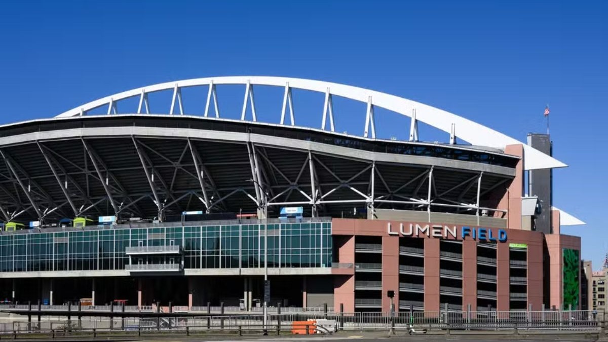 Lumen Field, em Seattle Fachada exterior do Lumen Field, em Seattle, com arco branco, vidro e letreiro 'LUMEN FIELD'.