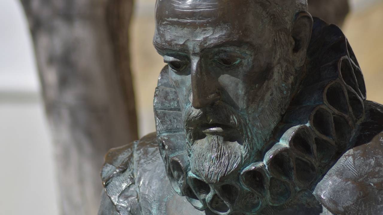 A estátua de Miguel de Cervantes representa o autor cujas ideias sobre leitura e experiência pautam a matéria Estátua de bronze de Miguel de Cervantes, barbudo e com gola de babados