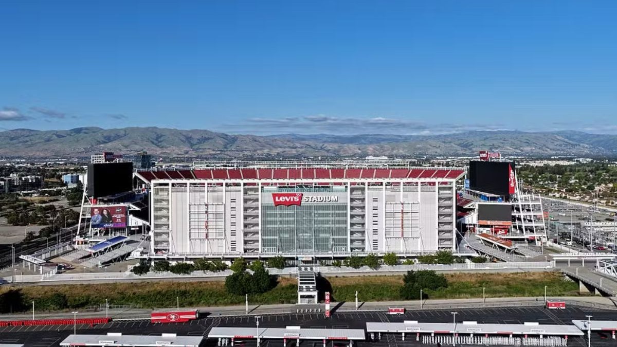 O Levi's Stadium, na Califórnia, ilustra as modernas arenas norte-americanas prontas para receber os jogos da Copa do Mundo de 2026. Vista aérea do Levi's Stadium, fachada branca e vermelha, letreiro 'Levi's Stadium', telões e estacionamento.