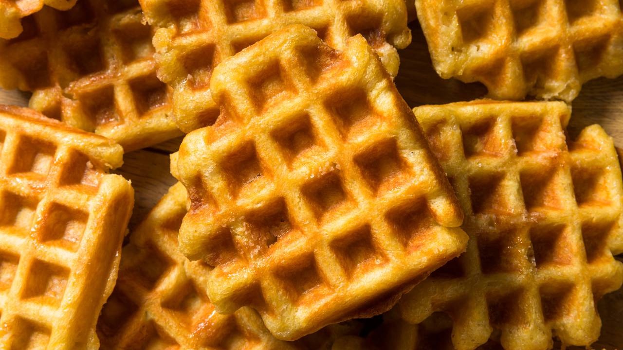 Prepare waffles saborosos com a nossa receita fácil, ideais para o café da manhã ou lanche rápido. Waffles dourados e empilhados, revelando a textura quadriculada