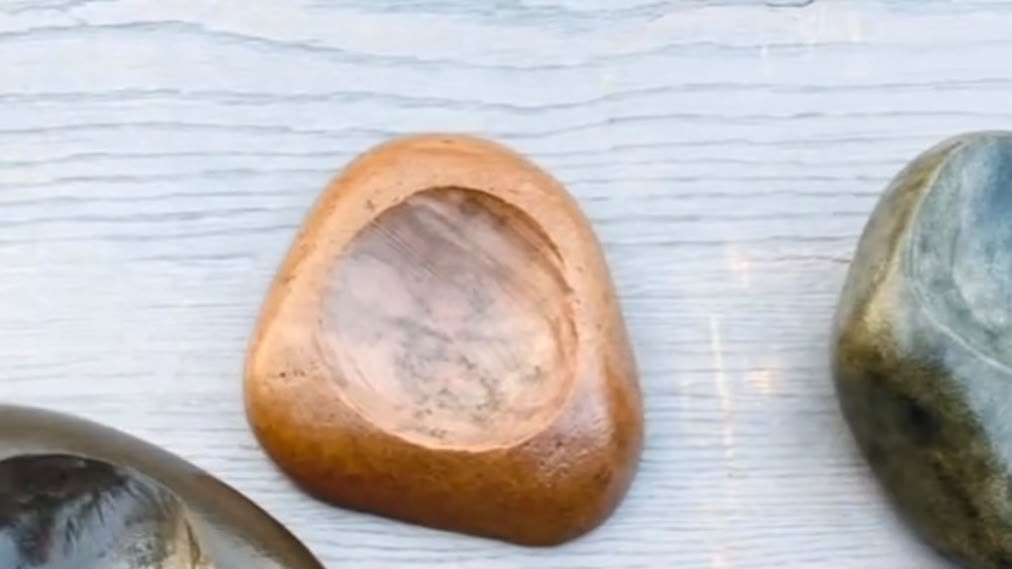 Tigelas de pedra oferecem uma alternativa natural e sofisticada para servir alimentos em qualquer ambiente Duas tigelas de pedra esculpidas, marrom e verde-acinzentada, sobre uma superfície de madeira clara