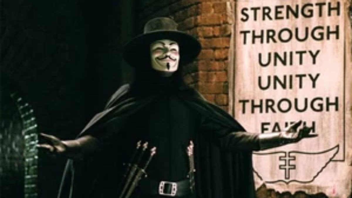 V de Vingan&ccedil;a com m&aacute;scara, capa, chap&eacute;u, bra&ccedil;os abertos, cartaz 