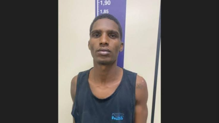 Fabrício Mateus da Silva, suspeito de matar o estudante Luiz Guilherme, foi preso em São João de Meriti. Foto: Divulgação Homem de pele escura com camiseta preta, cabelo curto, diante de régua de altura