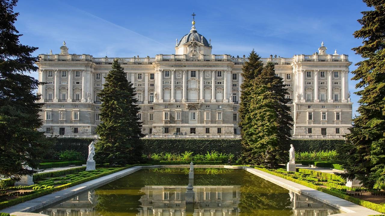 Palácio Real de Madrid Vista frontal do Palácio Real de Madrid, refletido em lago ornamental com jardins e árvores