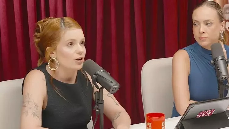 Viih Tube em gravação de podcast onde detalhou a estratégia de marketing por trás da história dos 46 beijos. Foto: Reprodução/YouTube Viih Tube (ruiva) e outra mulher em podcast, microfones, tablet com 'POD DELAS'.