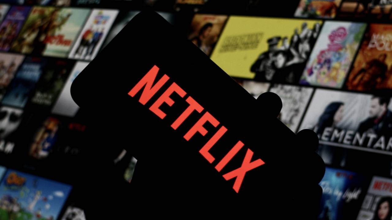 Netflix: o calendário de lançamentos de séries para julho de 2026 promete maratonas para todos os gostos. Close-up do logo vermelho da Netflix em uma tela, com pôsteres de séries borrados ao fundo.