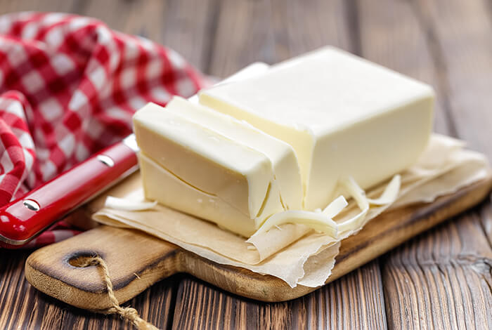 A bar of butter with some of its parts sliced.