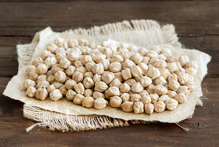 Raw chickpeas placed on top of a brown paper.