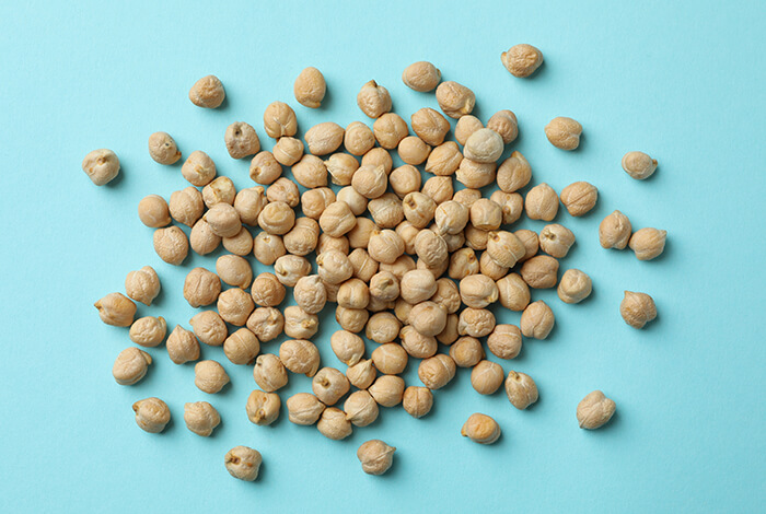 A handful of dried chickpeas displayed on a smooth surface.