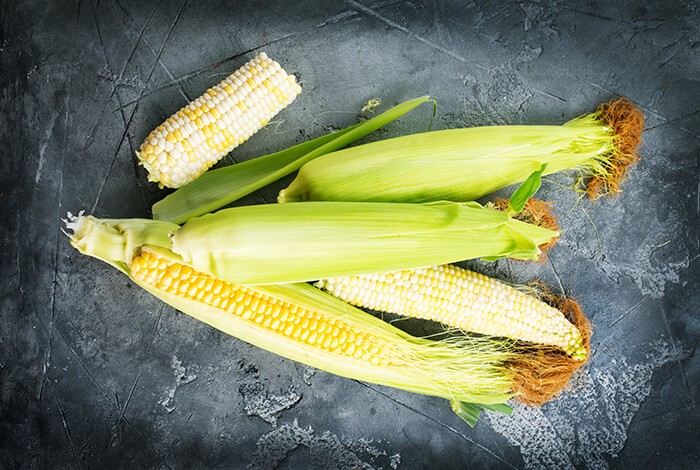 Four ears of raw corn.