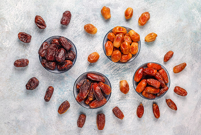 Different types of dried dates are placed in bowls.