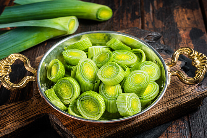 Sliced leeks filling a metal bowl.
