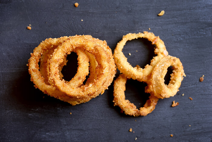 Fried onion rings on a smooth surface.