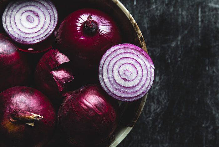 Bulbs of red onions fill up a bowl.