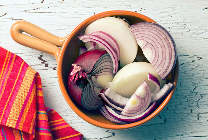 A bowl filled with sliced red onions.