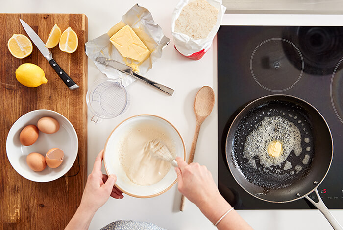 A person is making pancakes from scratch.